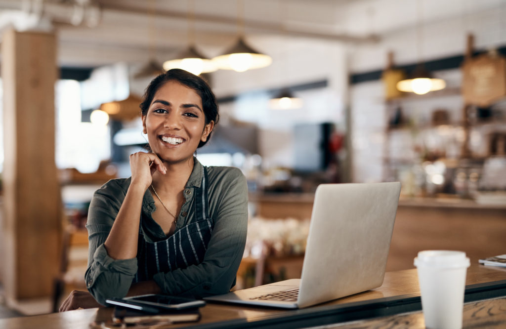 Shot of a young woman using a laptop while working in a cafe