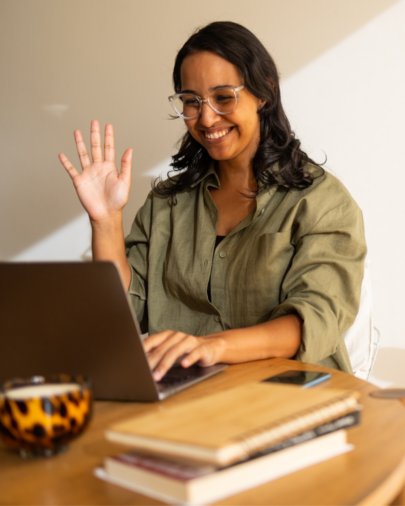 Woman smiling and waving to computer. Small Business Ideas + How To Get Started Today