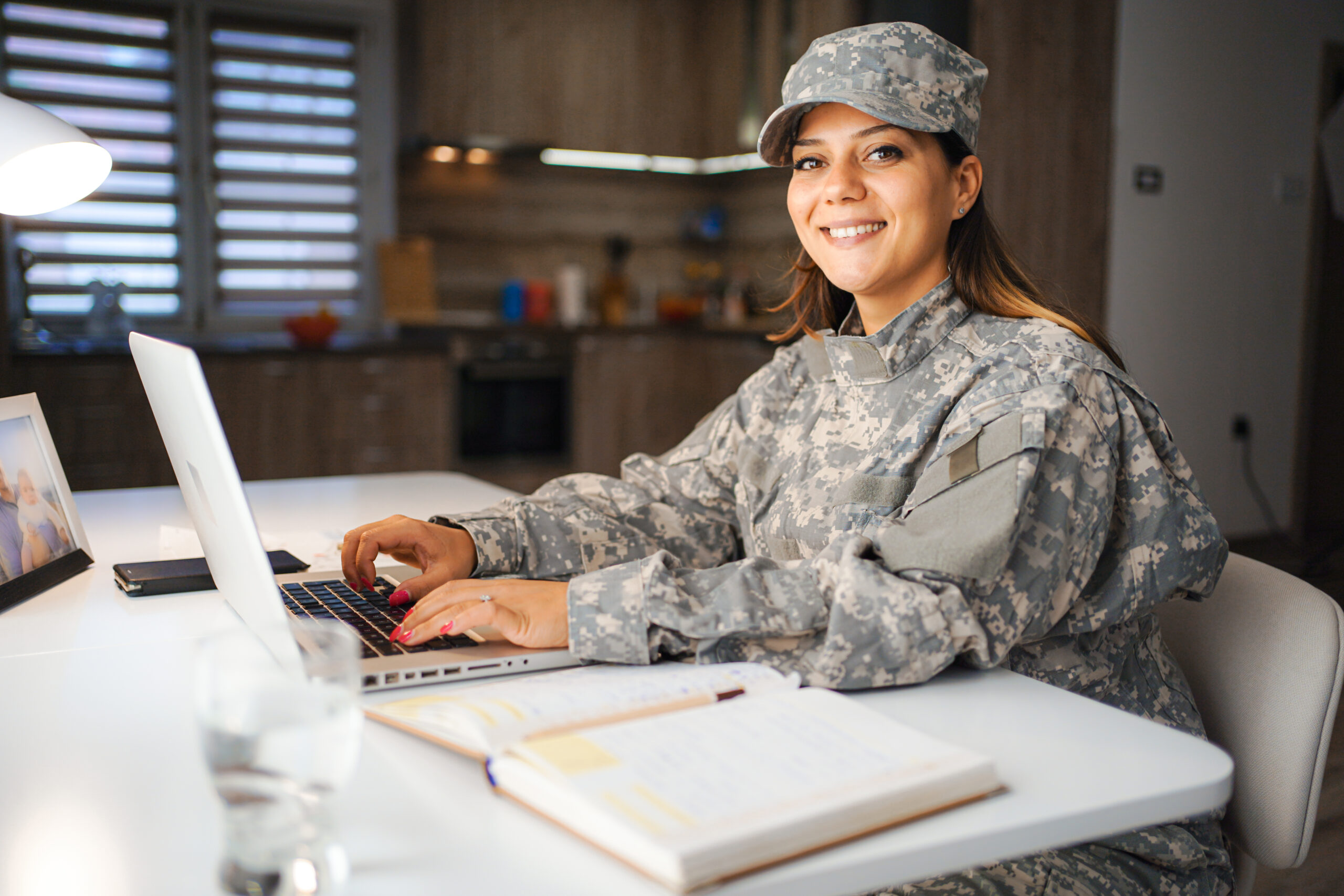 Portrait of a female soldier working on laptop at home Portrait of a female soldier working on laptop at home